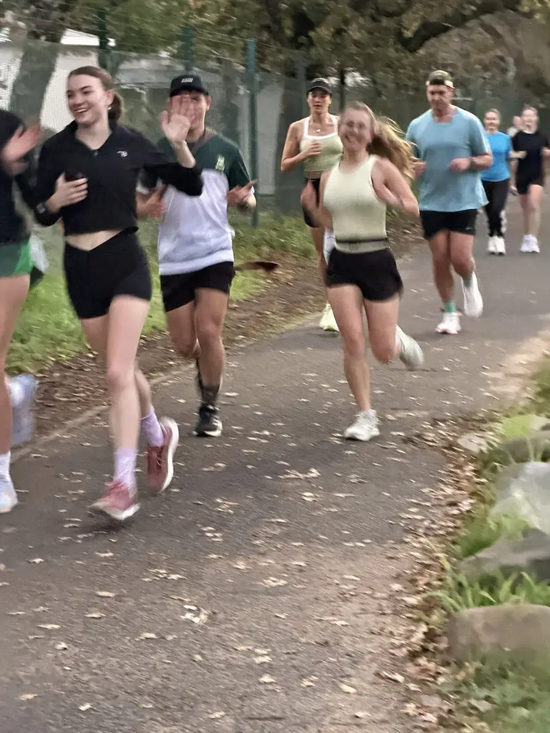 Run club members waving mid-run